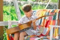 Child with guitar outdoor. Kids music and songs. Dreamy kids face. Smiling child playing outdoors in summer. Royalty Free Stock Photo