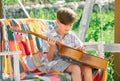 Child with guitar outdoor. Kids music and songs. Dreamy kids face. Smiling child playing outdoors in summer. Royalty Free Stock Photo