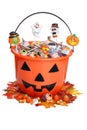 Child halloween pumpkin bucket with candy and fall