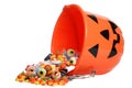 Child halloween pumpkin bucket spilling candy