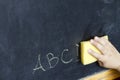 Child hand cleans letters abc education background