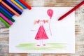 Child hand drawing Girl with red balloon with wax crayon