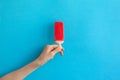 Child hand holding red ice cream popsicle on blue color background Royalty Free Stock Photo