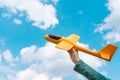 Child hand holding toy plane flying in blue sky Royalty Free Stock Photo