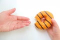 Child hand holds a bitten orange  donut holds out his mom hands on a white background Royalty Free Stock Photo