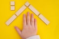 Child hand in a house made of wooden pegs and blocks Royalty Free Stock Photo