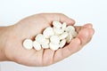 Child hand with a lot of medical pills on white background with copy space Royalty Free Stock Photo