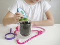 Child hand measuring temperature with thermometer. Experiment on a young plant. Caring for a new life. Selective focus. Save earth