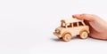 Child hand playing with natural wooden car toy on white backgrou Royalty Free Stock Photo