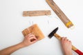 child hand with pliers and hammer on a white table