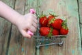 Child hand pushing a small trolley with strawberries Royalty Free Stock Photo