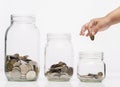 Child hand putting a coin into glass bottle, future saving concept