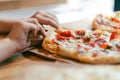 Child hand taking slice of fresh delicious pepperoni pizza served on craft paper Royalty Free Stock Photo