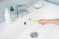 Child hand washing the toothbrush under running water over the washbasin Royalty Free Stock Photo