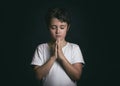 Child with hands clasped together praying