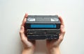 Child hands hold stack of 4 VHS tapes. Black and blue cassettes. White background. Hands placed over middle of stack, fingers Royalty Free Stock Photo