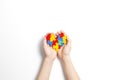 Child hands holding colorful heart on white background. World autism awareness day concept Royalty Free Stock Photo