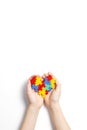 Child hands holding colorful heart on white background. World autism awareness day concept Royalty Free Stock Photo