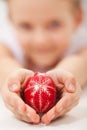 Child hands holding traditional decorated easter egg