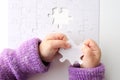 Child hands holds the last puzzle piece of a Jigsaw puzzle Royalty Free Stock Photo