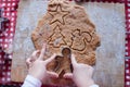 Child hands making from dough gingerbread man