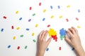 Child hands making multicolor heart on white background. Top view