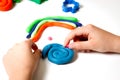 Child hands molding modeling clay or plasticine on white table Royalty Free Stock Photo
