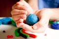 Child hands molding modeling clay or plasticine on white table Royalty Free Stock Photo