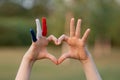 Child hands painted in France flag color forming a heart symbol and love gesture outdoor Royalty Free Stock Photo