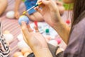 Child hands painting Easter eggs with family