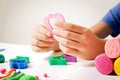 Child hands playing with modeling clay or plasticine on white table Royalty Free Stock Photo