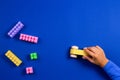 Child hands playing with wooden toy car on blue background Royalty Free Stock Photo