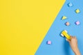 Child hands playing with wooden toy car and colorful building blocks on blue and yellow background, top view Royalty Free Stock Photo