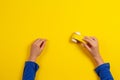 Child hands playing with wooden toy car on yellow background, top view Royalty Free Stock Photo