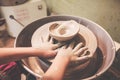 Child hands working with clay on pottery wheel Royalty Free Stock Photo