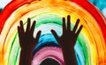Child hands touch painting rainbow on window Royalty Free Stock Photo