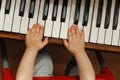 Child hands on a white piano key Royalty Free Stock Photo