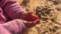 Child hands in sand at beach, time running concept, closeup