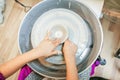 Child hands working with clay on pottery wheel Royalty Free Stock Photo