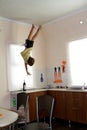 Child hanging up side down in kitchen Royalty Free Stock Photo