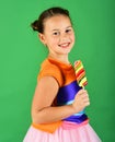 Child with happy face poses with candy on green background. Royalty Free Stock Photo