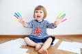 Child happy smiling sitting on floor playing with felt tip pens. baby girl painting and playing. colorful stuff felt pen caps Royalty Free Stock Photo