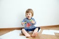 Child happy smiling sitting on floor playing with stuff felt tip pens. baby girl painting and playing. colorful felt pen caps Royalty Free Stock Photo