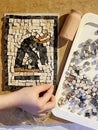 The child has assembled a mosaic of stones. Antique mosaic