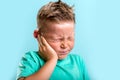 Child has earache. School boy has sore ear. Little kid covered ear with hand and closed eyes. Kid suffering from otitis Royalty Free Stock Photo