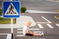 A child has fallen on the road at a pedestrian crossing and is holding his leg, traffic rules for children Royalty Free Stock Photo