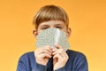 The child has playing cards in front of his face. Gambling anonymity concept