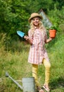 Child in hat with shoulder blade small shovel hoe. Happy smiling gardener girl. Little kid hold flower pot. Spring Royalty Free Stock Photo