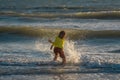 Child have fun on tropical sea beach resort. Funny baby boy run with splashes by water pool along surf edge. Active kids Royalty Free Stock Photo