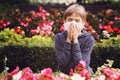 Child having allergy. Boy sitting with tissue in city park Royalty Free Stock Photo